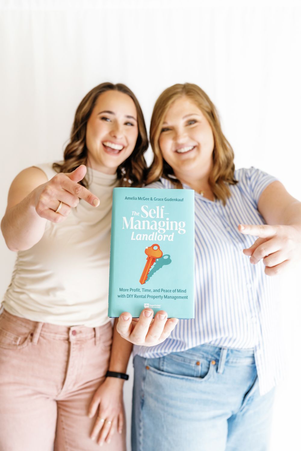 Amelia and Grace holding their book, The Self-Managing Landlord
